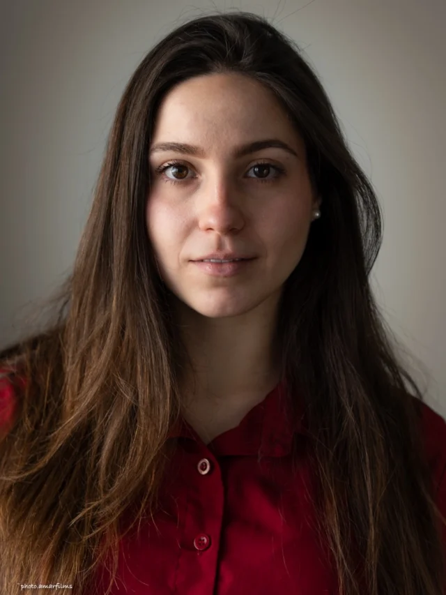 Studio headshot of a woman in a red blouse