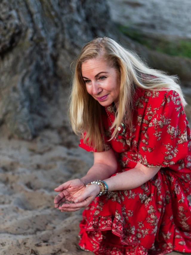 Woman in a red floral dress on a sandy path